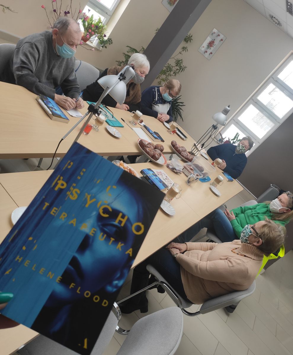 Grupa uczetników DKK siedzi przy stole w maskach