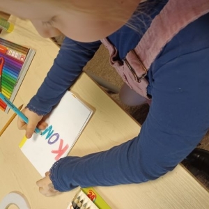 Dziewczynka pisze kolorowe litery