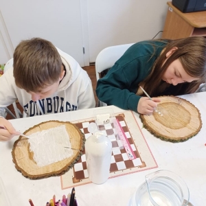 Dziewczyna i chłopiec rysują na drewnie