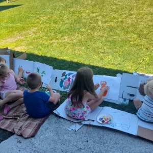 Dzieci siedzą wspólnie i rysują obrazki