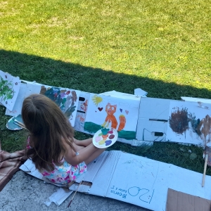Dziewczynka maluje farbami na kartce