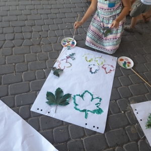 Dziewczynka odbija zielone liście na plakacie