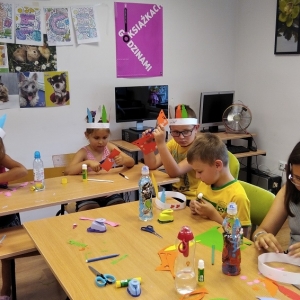 Dzieci wycinają i kleją elementy z kolorowego papieru