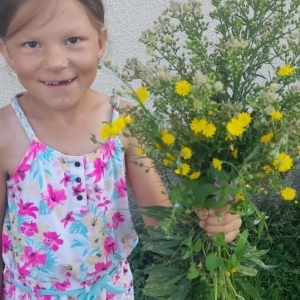 Dziewczynka trzyma w ręce kwiatki