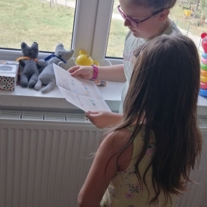 Dzieci czytają tekst z kartki
