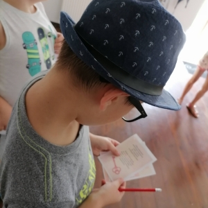 Chłopczyk w kapeluszu przygląda się kartce