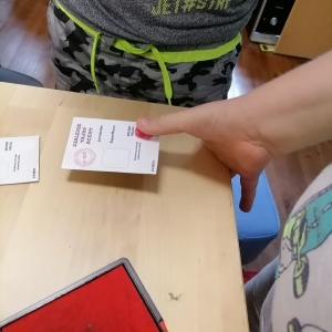 Uczestnik odbija odcisk swojego palca na kartce