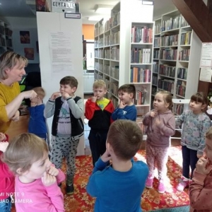 Dzieci naśladują gesty pokazywane przez bibliotekarkę